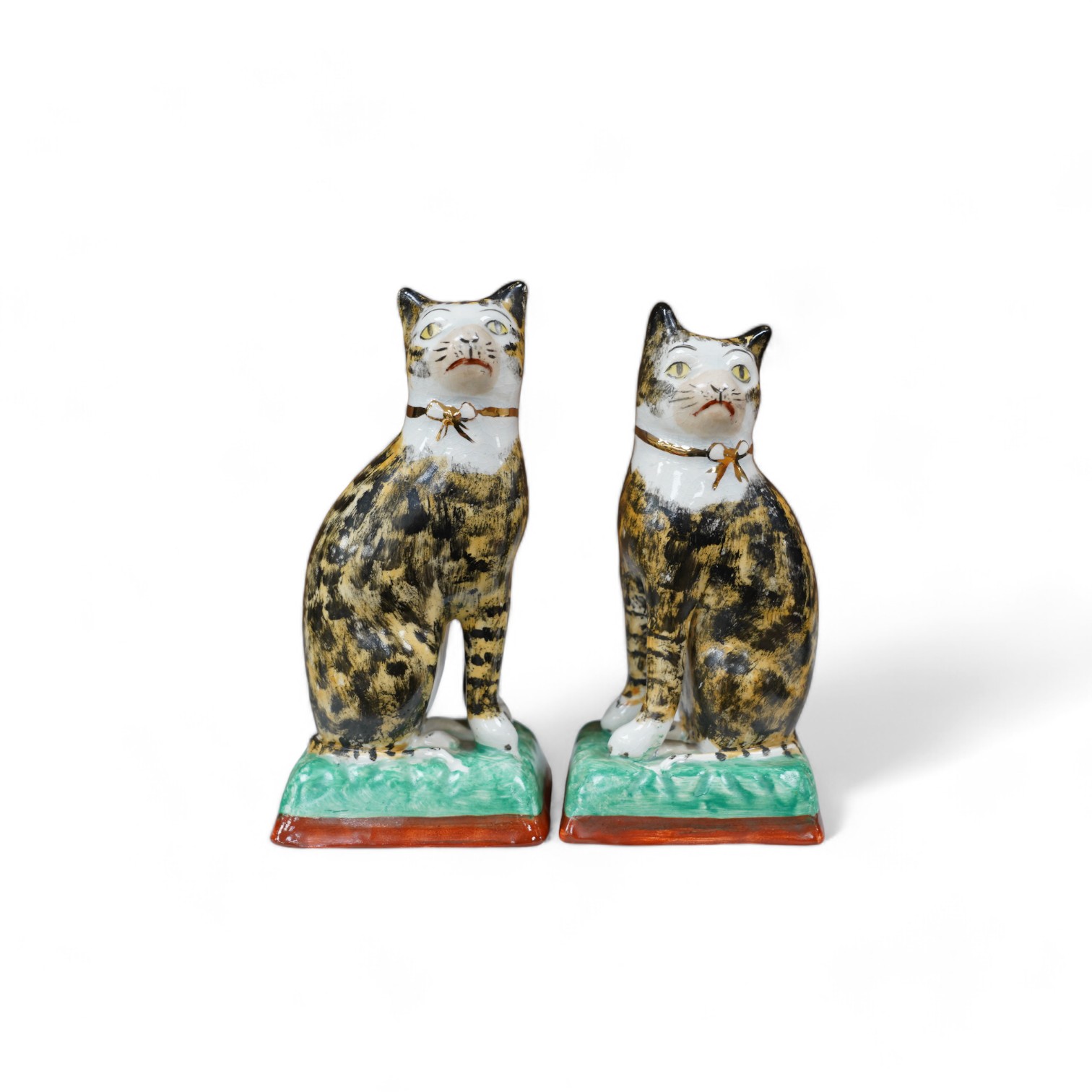 A pair of early 20th century Staffordshire cats, 17cm. Condition - good, some crazing